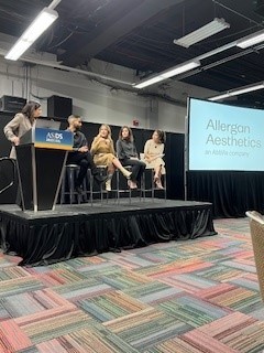 Five women on a board giving a presentation