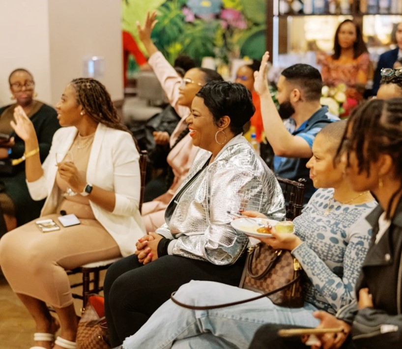 African Americans sitting in a meeting raising their hands to speak