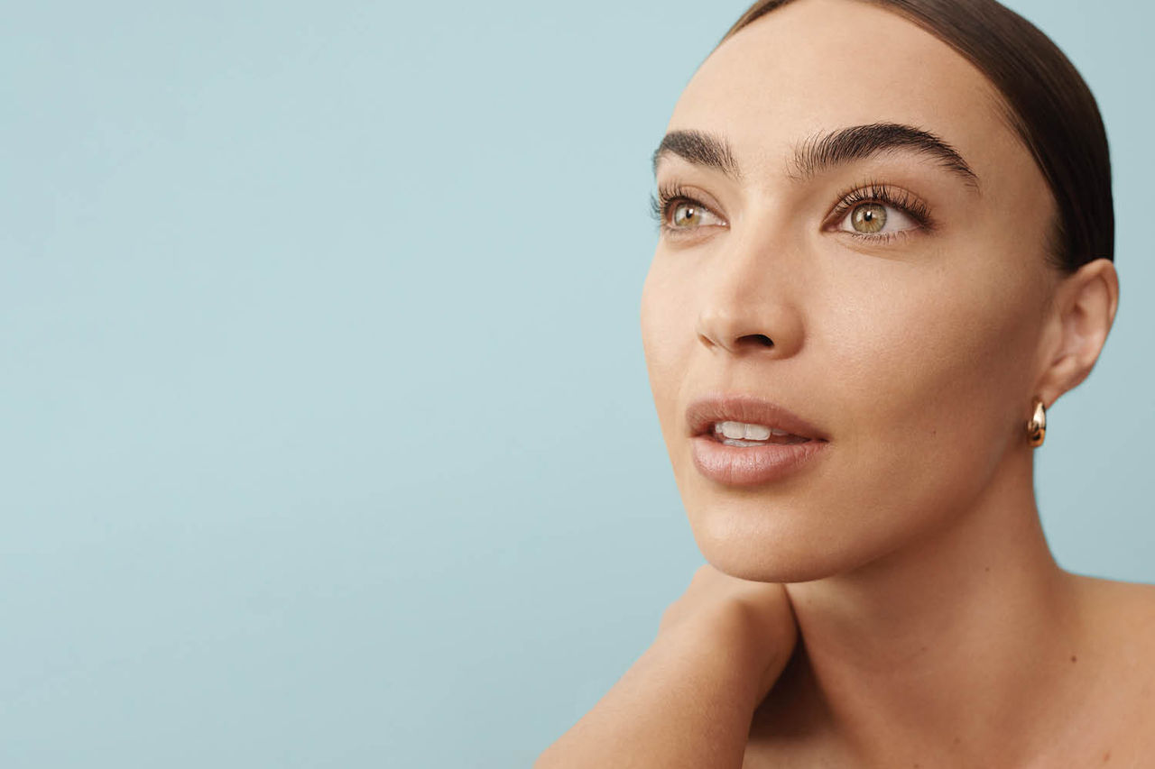 a female looking out on a light blue background